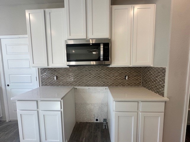 kitchen featuring white cabinetry, dark hardwood / wood-style flooring, light stone countertops, and tasteful backsplash