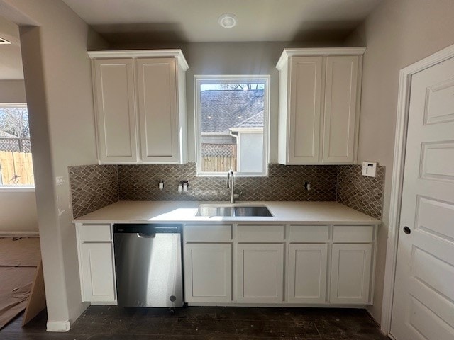 kitchen featuring white cabinets, decorative backsplash, dishwasher, and sink