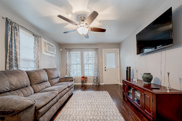 living room with a wall unit AC, ceiling fan, a textured ceiling, and dark hardwood / wood-style floors