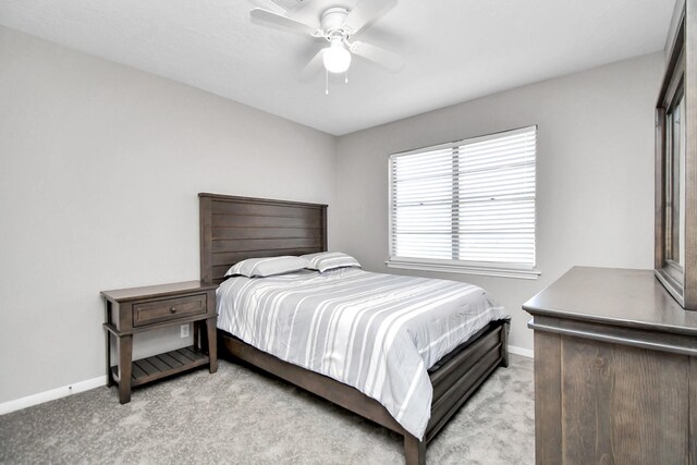 bedroom with ceiling fan and light carpet