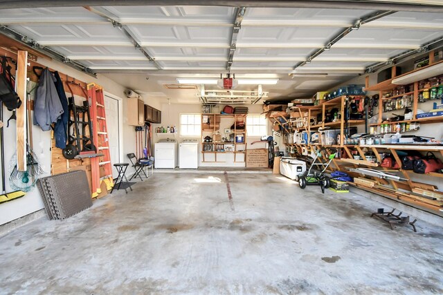 garage with a workshop area, separate washer and dryer, and a garage door opener