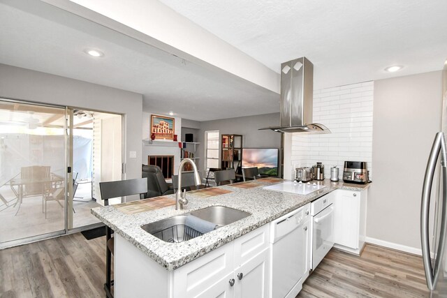 kitchen featuring white appliances, sink, light hardwood / wood-style flooring, white cabinetry, and island exhaust hood