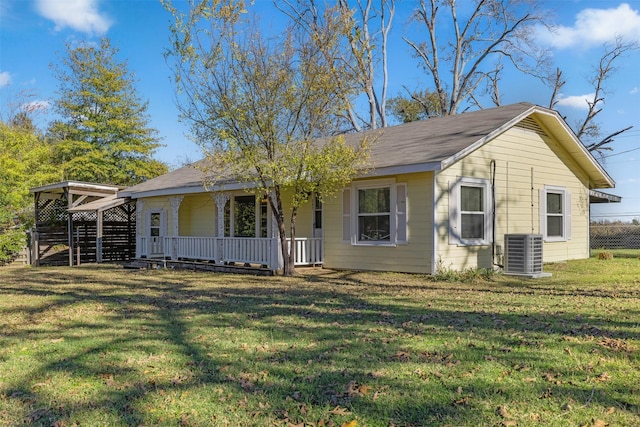 view of front of house featuring central air condition unit, covered porch, and a front yard