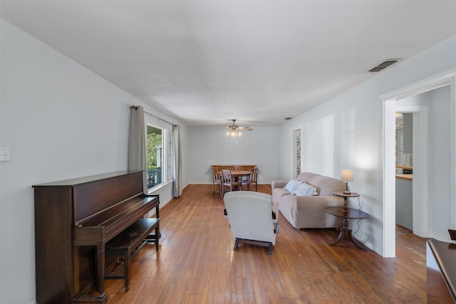 living room with wood-type flooring and ceiling fan