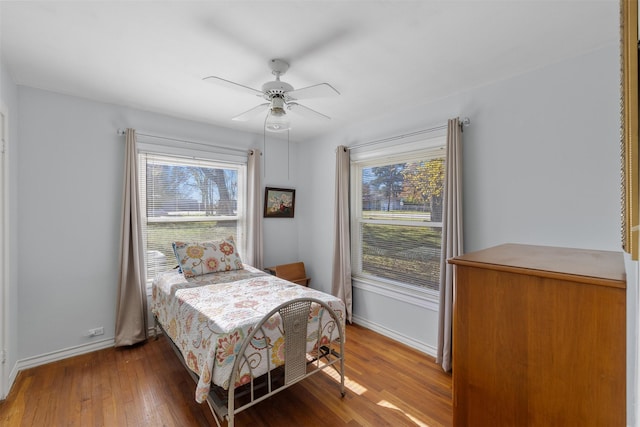 bedroom featuring hardwood / wood-style flooring, multiple windows, and ceiling fan