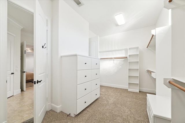 walk in closet featuring light colored carpet