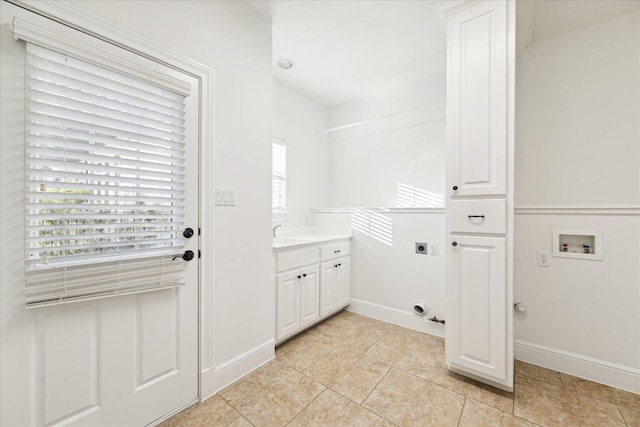 clothes washing area featuring cabinets, hookup for a washing machine, electric dryer hookup, sink, and light tile patterned floors