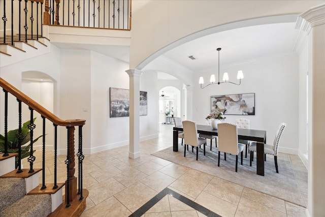 dining area with decorative columns, light tile patterned floors, crown molding, and an inviting chandelier