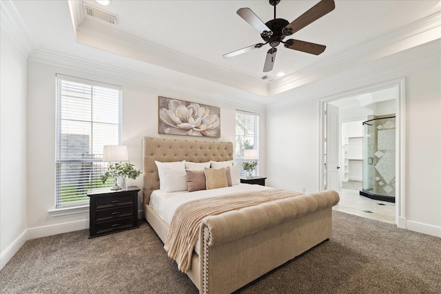 carpeted bedroom with a raised ceiling, ensuite bath, ceiling fan, and crown molding