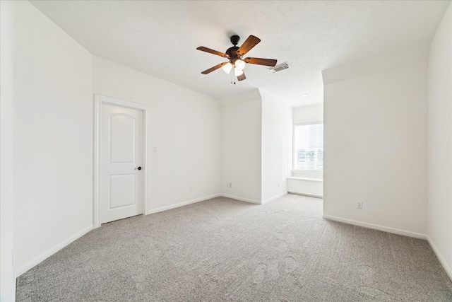 carpeted spare room with ceiling fan