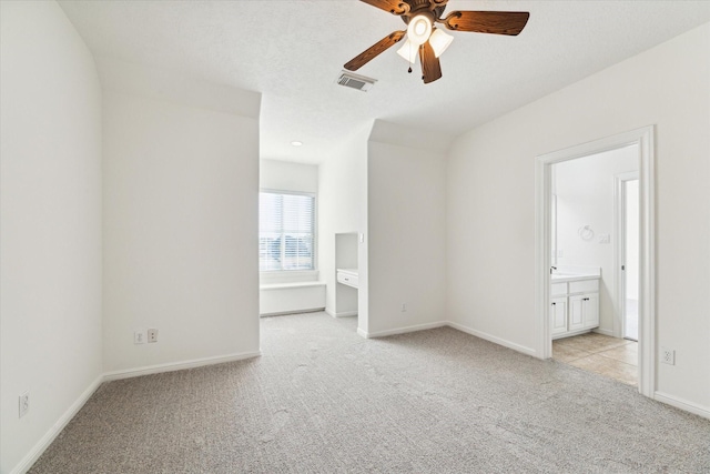 carpeted spare room featuring ceiling fan and a textured ceiling