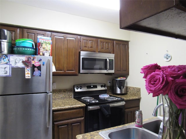 kitchen featuring dark brown cabinets, sink, and stainless steel appliances