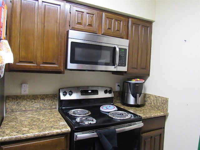 kitchen with light stone countertops and appliances with stainless steel finishes