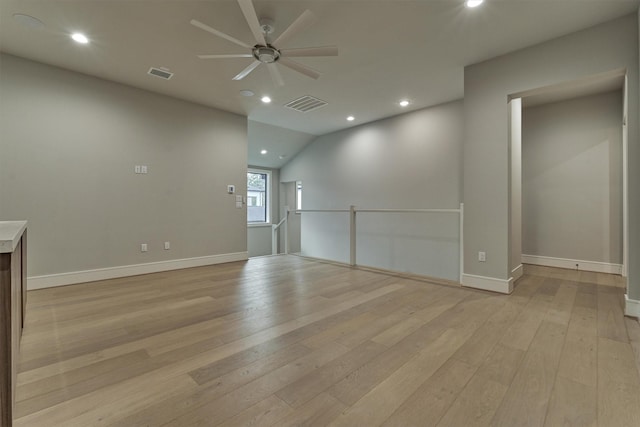 empty room featuring vaulted ceiling, light hardwood / wood-style flooring, and ceiling fan