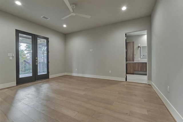 empty room with ceiling fan, light hardwood / wood-style floors, and french doors