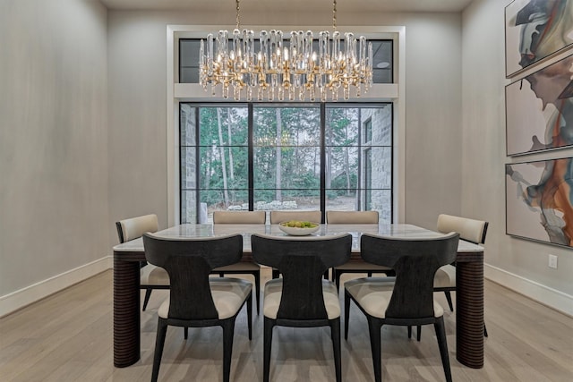 dining space with hardwood / wood-style floors and a notable chandelier