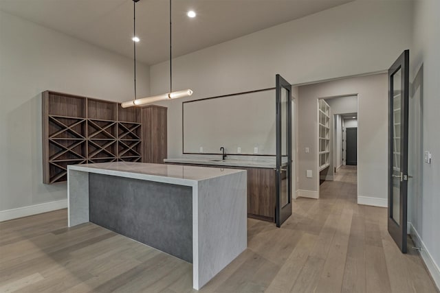 kitchen with a kitchen island, light wood-type flooring, and hanging light fixtures