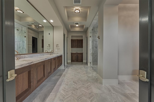 bathroom with vanity, a shower with shower door, and a tray ceiling