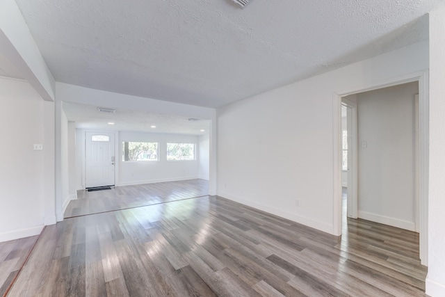 unfurnished living room with hardwood / wood-style floors and a textured ceiling