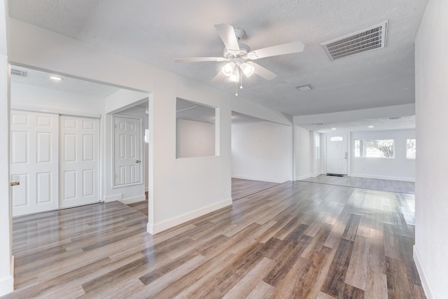 spare room featuring ceiling fan, light hardwood / wood-style floors, and a textured ceiling