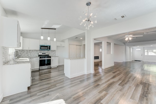 kitchen featuring pendant lighting, white cabinets, sink, light hardwood / wood-style floors, and stainless steel appliances