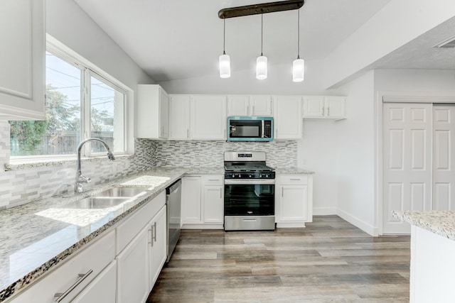 kitchen featuring white cabinets, sink, hanging light fixtures, tasteful backsplash, and stainless steel appliances