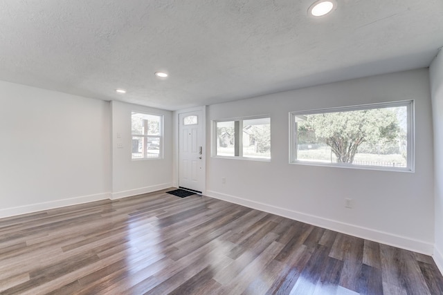 spare room with hardwood / wood-style floors, plenty of natural light, and a textured ceiling