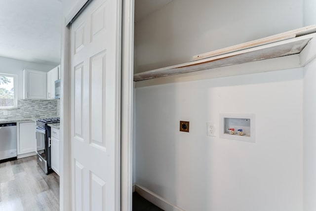 clothes washing area featuring washer hookup, light hardwood / wood-style flooring, and electric dryer hookup