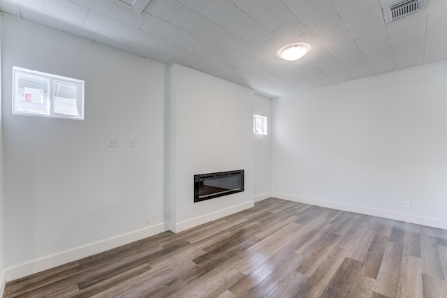 basement with wood-type flooring and heating unit