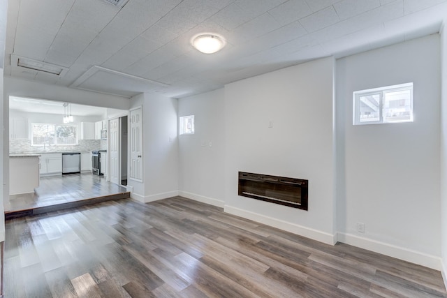 unfurnished living room featuring heating unit and hardwood / wood-style floors