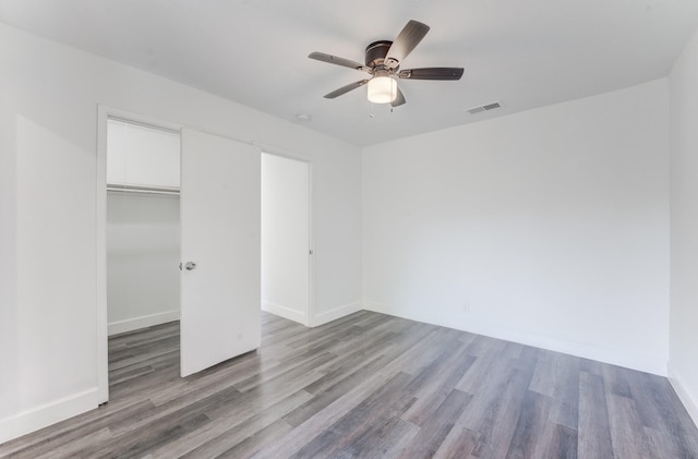 unfurnished bedroom featuring ceiling fan, light hardwood / wood-style floors, and a closet