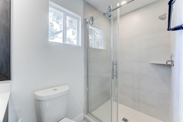 bathroom with toilet and an enclosed shower