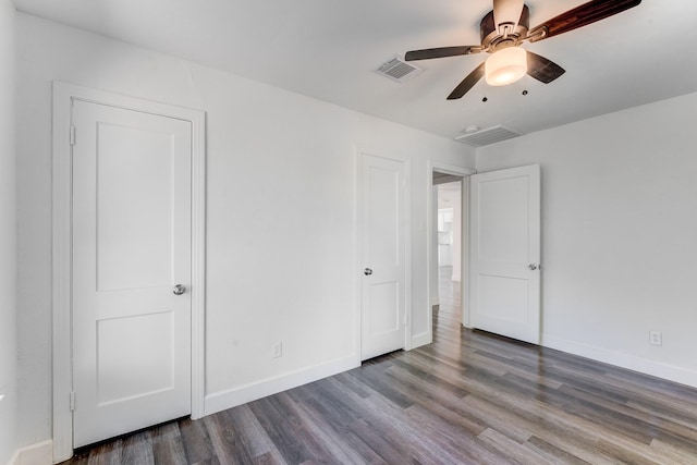 unfurnished bedroom with ceiling fan and dark hardwood / wood-style flooring