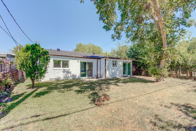 rear view of property featuring a lawn