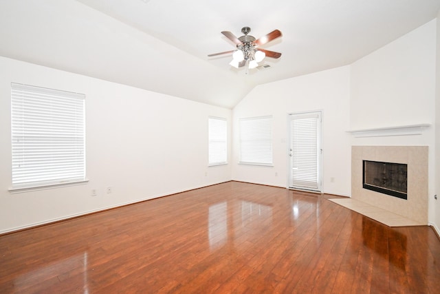 unfurnished living room with a tile fireplace, ceiling fan, hardwood / wood-style floors, and lofted ceiling