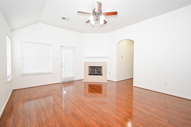 unfurnished living room with lofted ceiling, ceiling fan, light wood-type flooring, and a fireplace