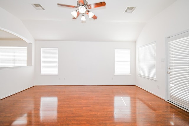 empty room featuring hardwood / wood-style floors, plenty of natural light, and vaulted ceiling