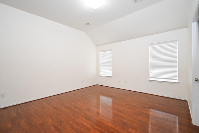 empty room featuring dark hardwood / wood-style floors and vaulted ceiling