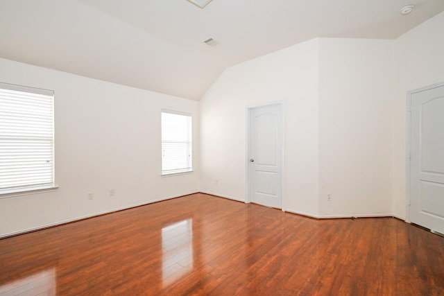 empty room featuring hardwood / wood-style floors and vaulted ceiling