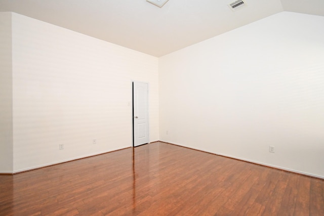 empty room with hardwood / wood-style flooring and vaulted ceiling