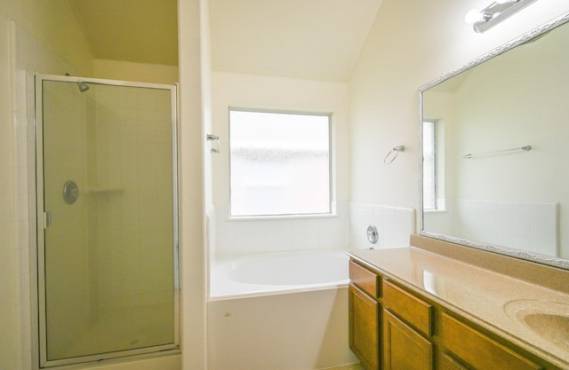 bathroom featuring shower with separate bathtub, vanity, and lofted ceiling