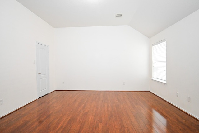 empty room with wood-type flooring and lofted ceiling