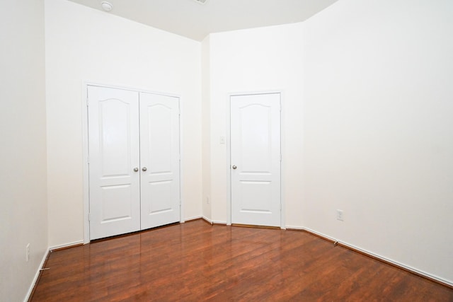 unfurnished bedroom featuring a closet and dark wood-type flooring