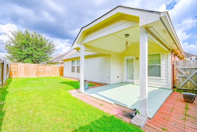 rear view of property featuring a lawn and a patio