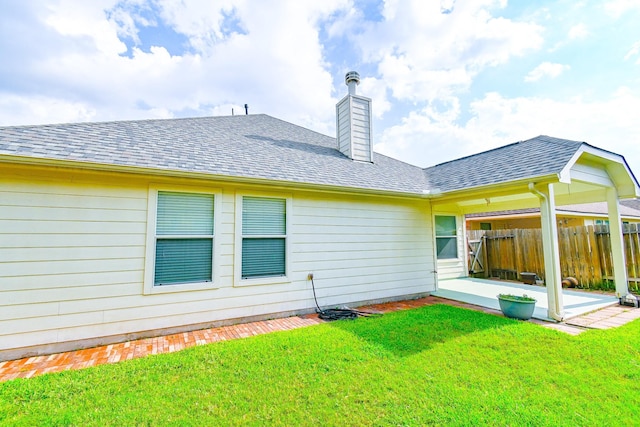 rear view of property with a yard and a patio area