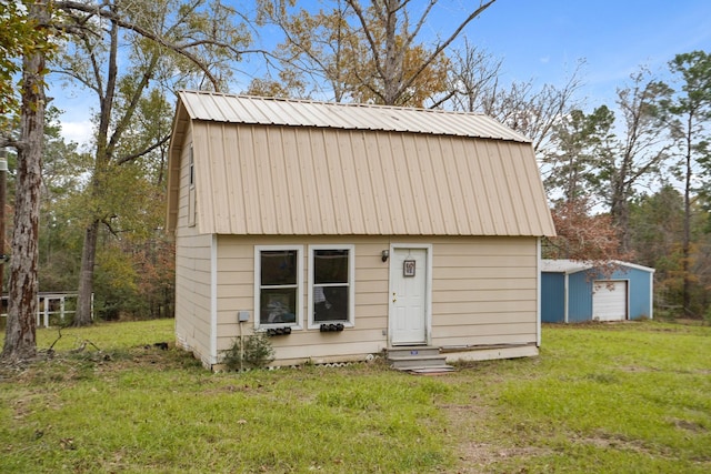 view of front of house with an outdoor structure and a front yard