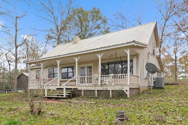 view of front of home featuring central AC unit, covered porch, and a front yard