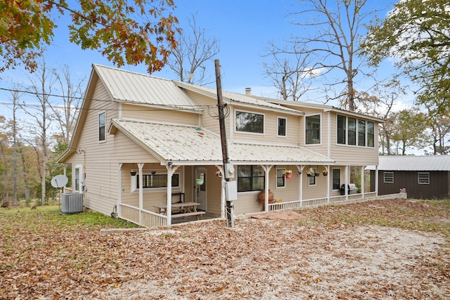 view of front of home with a porch, an outbuilding, and central air condition unit