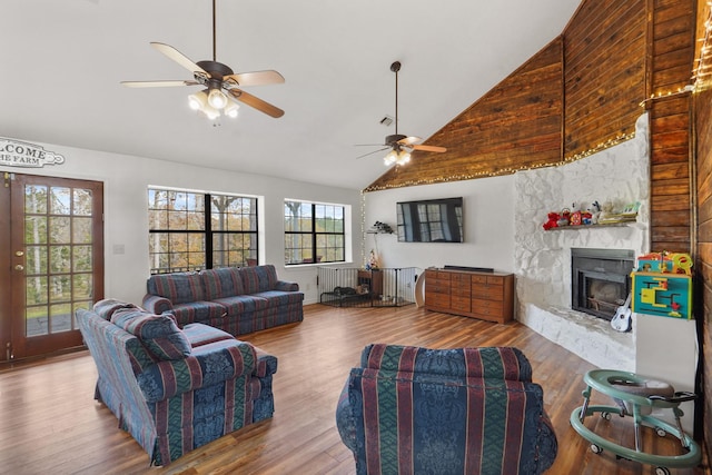 living room featuring a fireplace, ceiling fan, hardwood / wood-style floors, and high vaulted ceiling