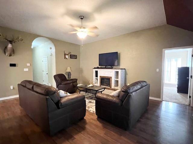 living room with ceiling fan, dark hardwood / wood-style flooring, and lofted ceiling